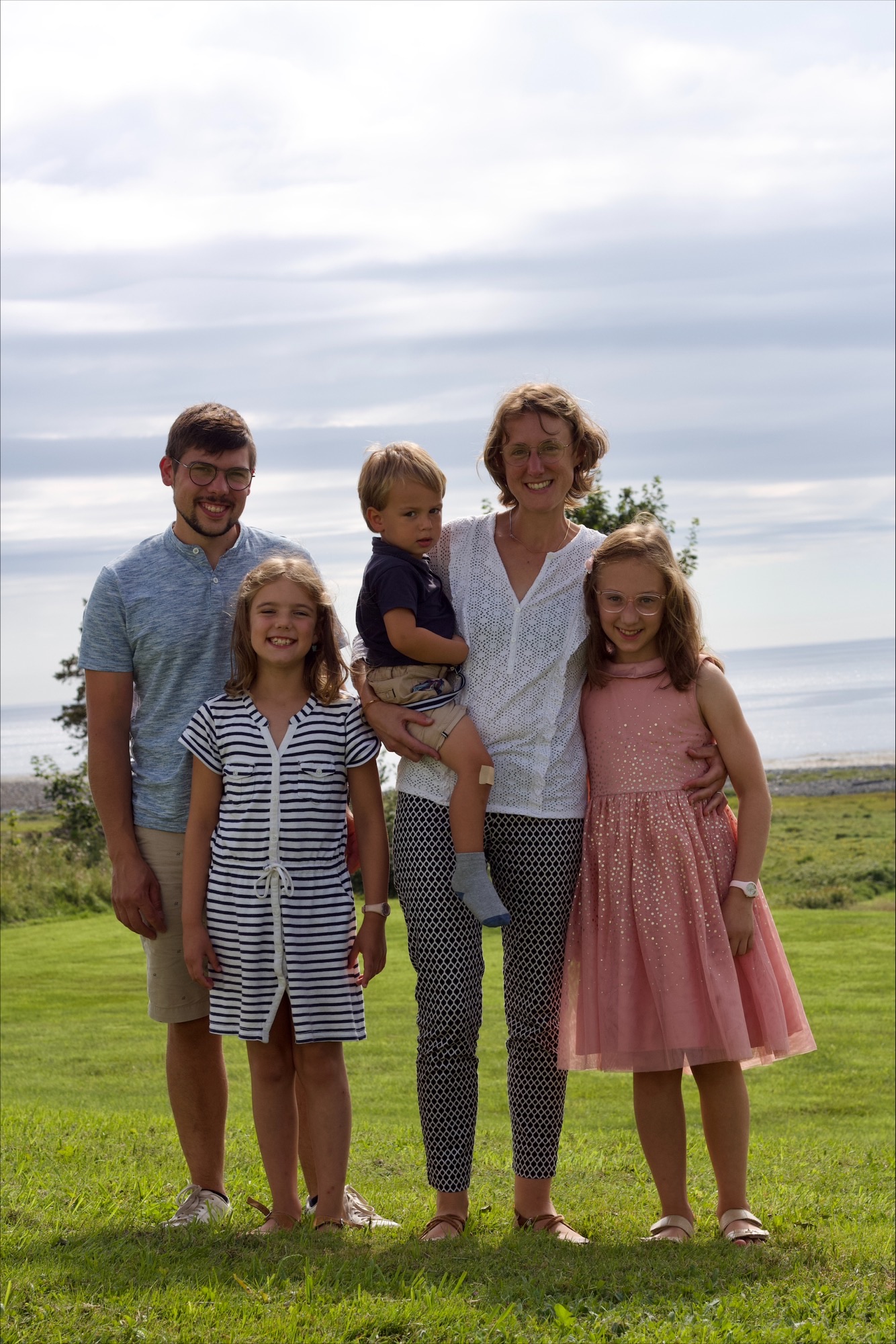 Image d'une famille belge (un homme et une femme avec leurs trois enfants) qui a immigré au Canada et s'est installée à Clare devant la baie Sainte-Marie.