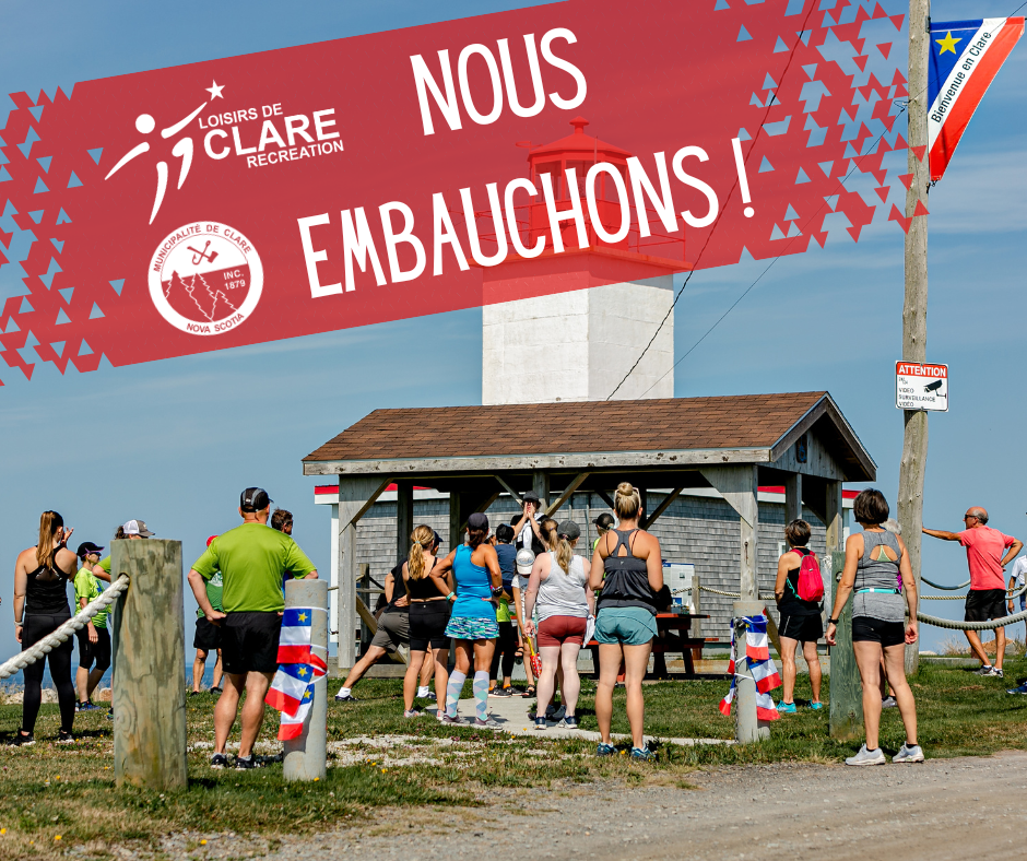 Un groupe de personnes rassemblées devant le phare du Cap Sainte-Marie avant la course de plage Cape-to-Cliff avec le texte "Nous embauchons !".