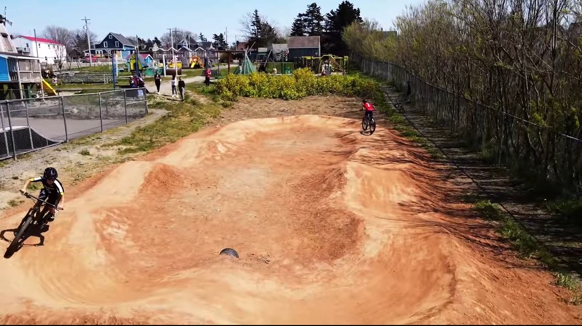 photo of two kids riding on the pump track