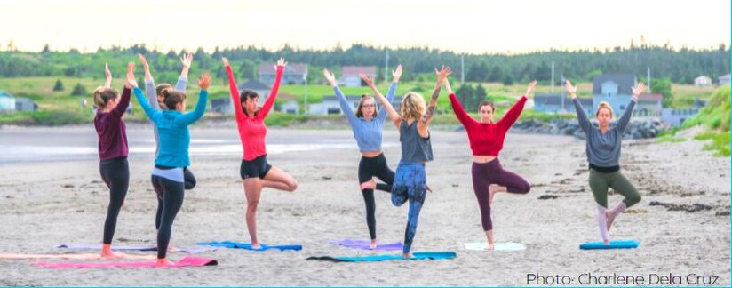 photo of women doing yoga on the beach