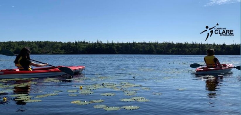 deux personnes en kayak dans un lac sur une journée ensoleilé